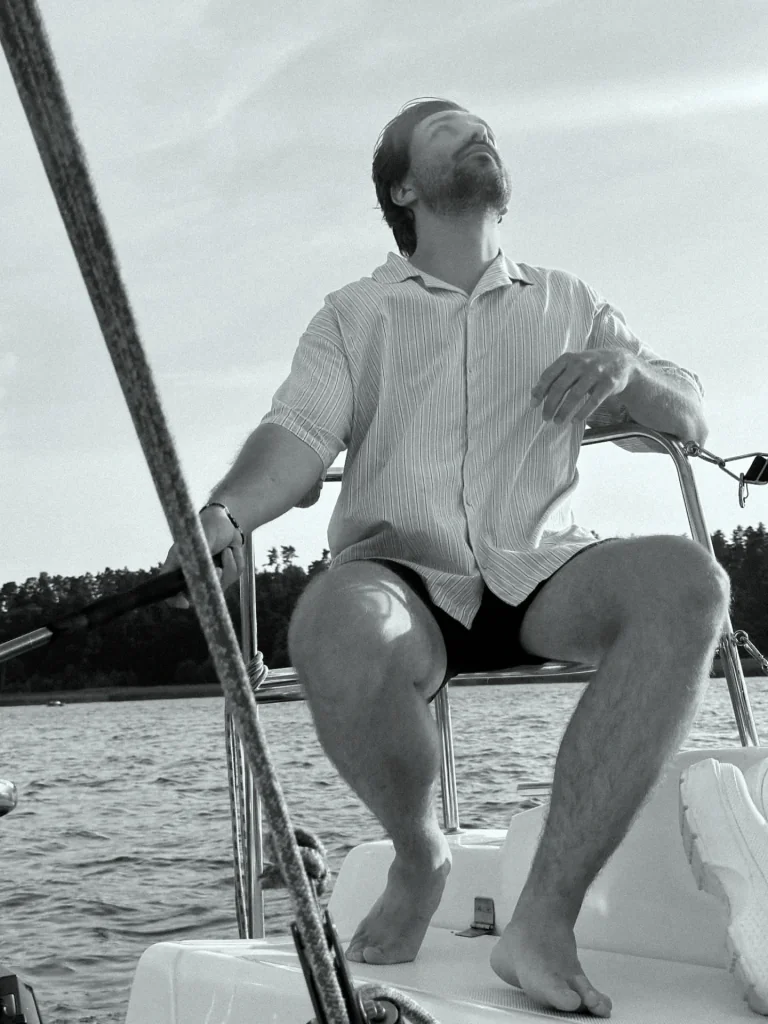 Filip at the helm of a sailboat on a lake